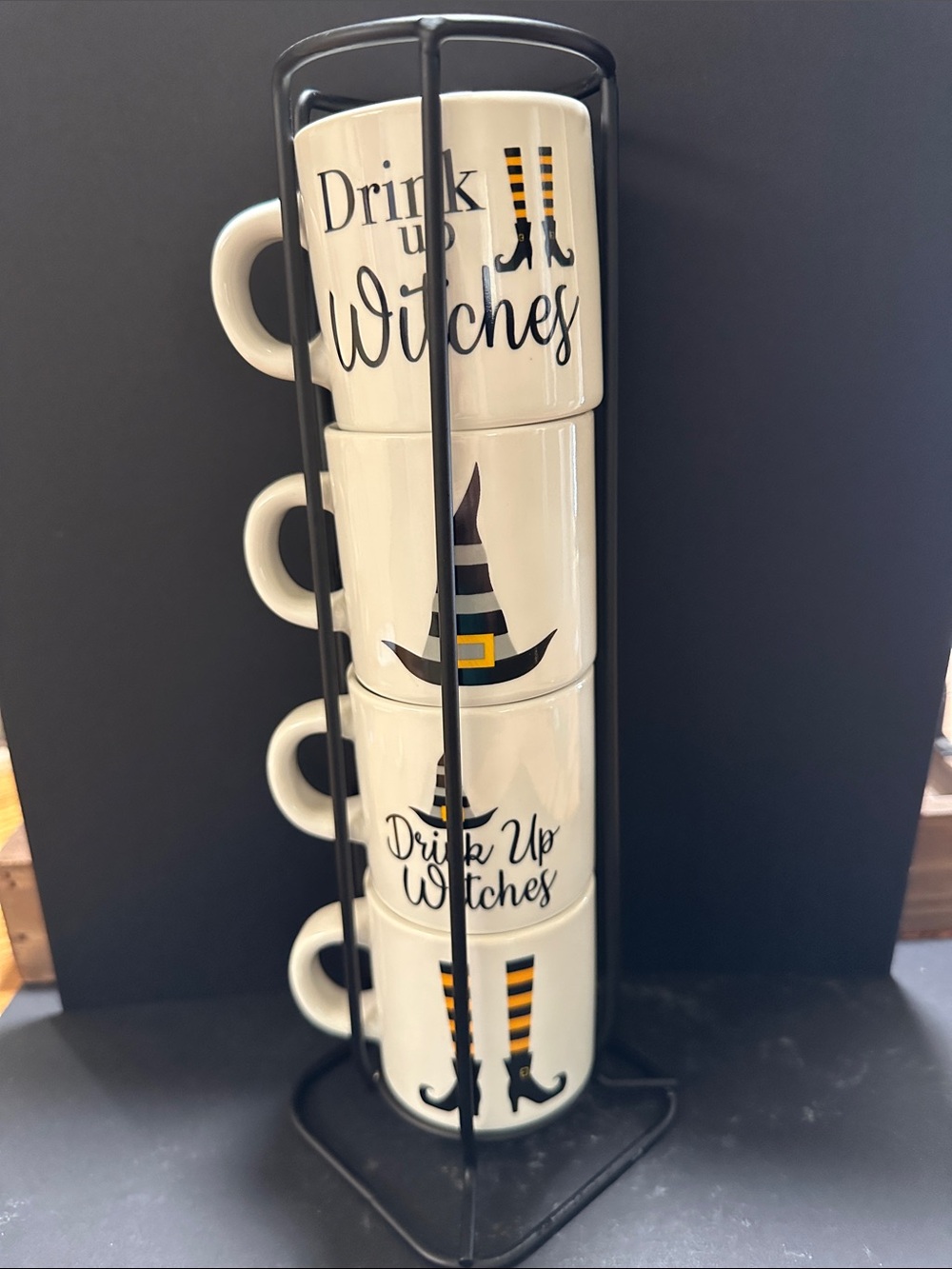 Drink Up Witches stacking ceramic mug set with a black metal stand.